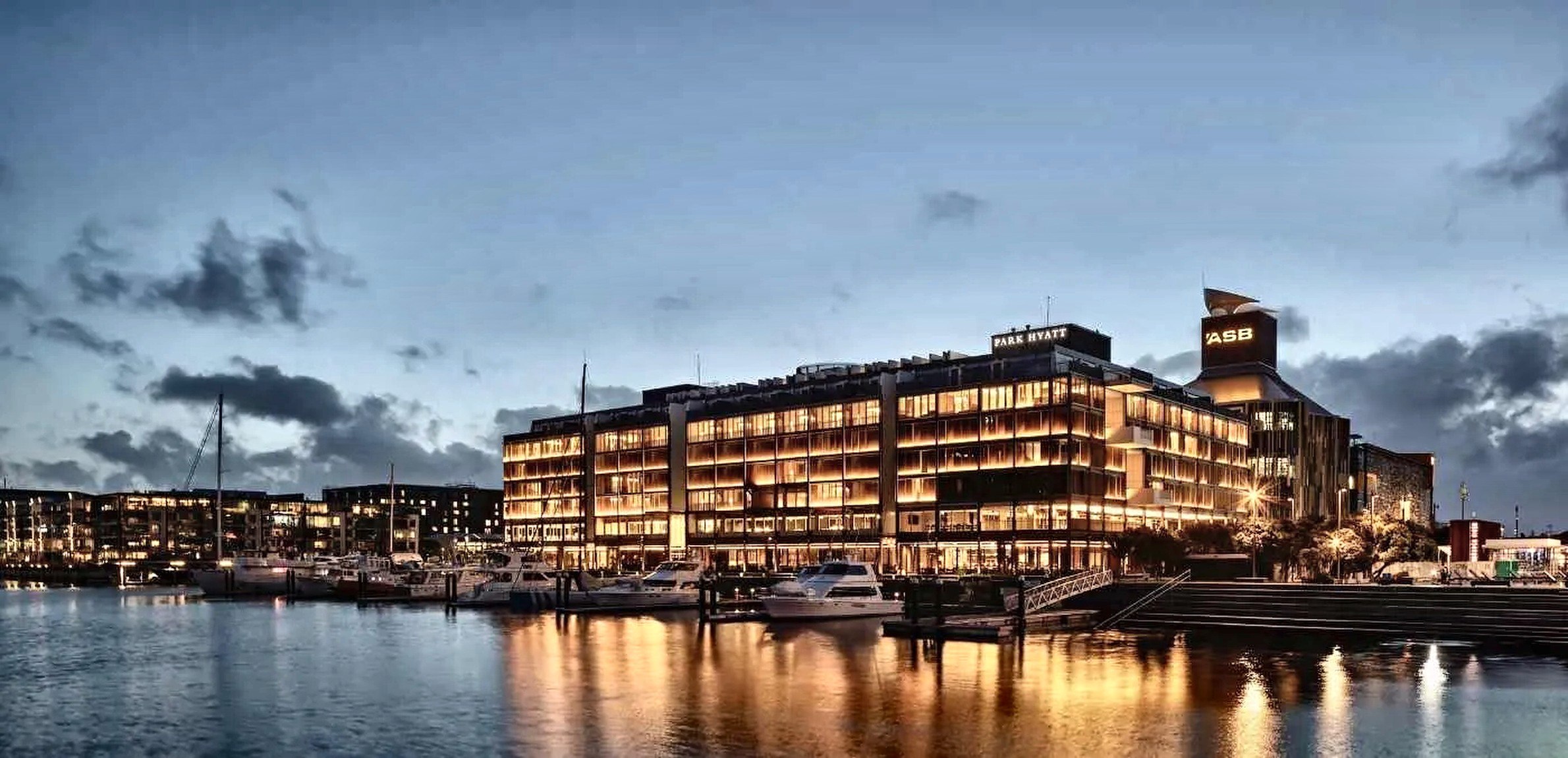 Park Hyatt Auckland lit at dusk on the Wynyard Quarter waterfront